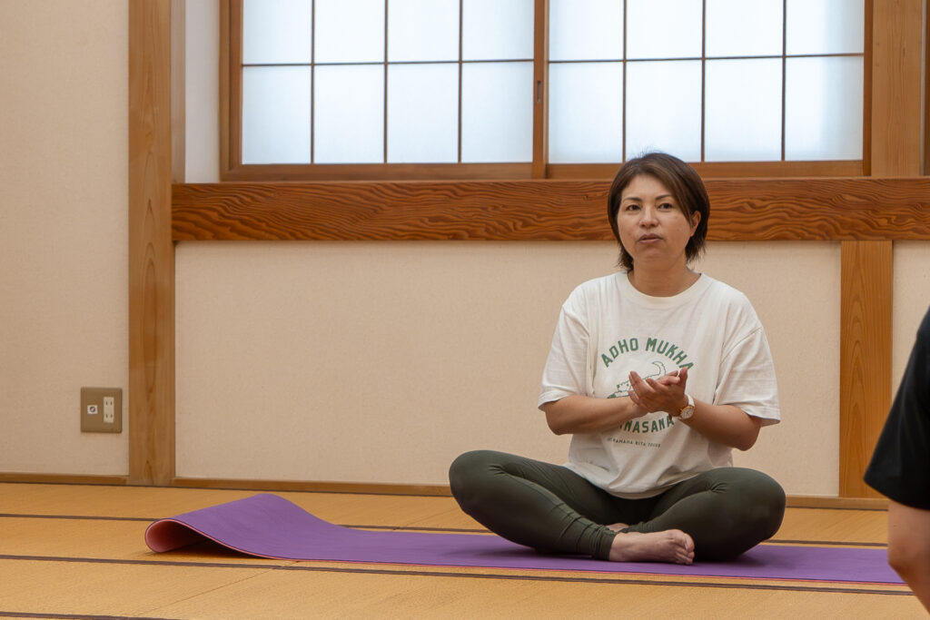 ヨガマットの上で生徒に語り掛ける大人ヨガ講師の大橋睦子先生